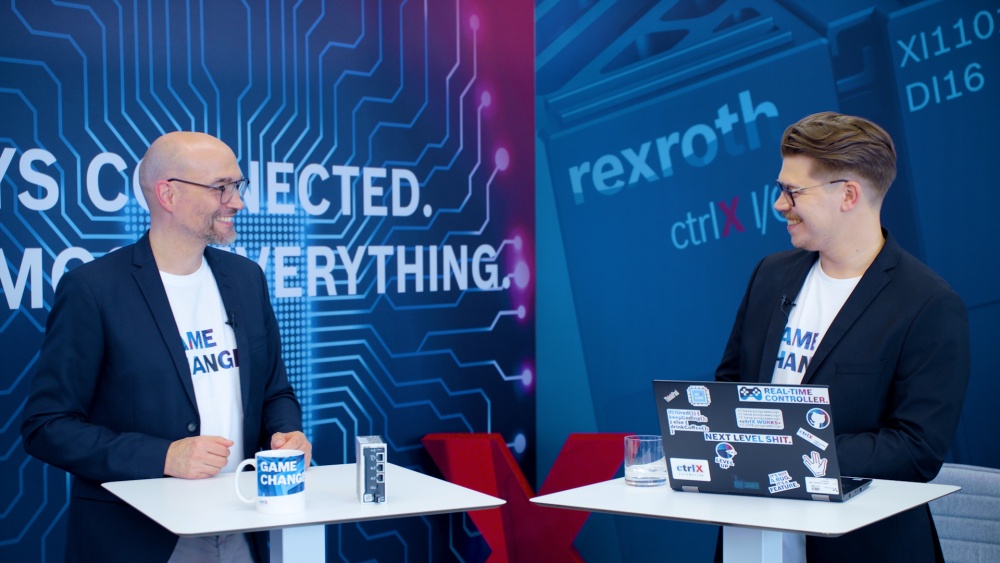 Host Christian Zentraf and his guest Benedikt Rüb stand at meeting tables and talk about ctrlX Configurator, the configuration tool of the automation solution ctrlX AUTOMATION